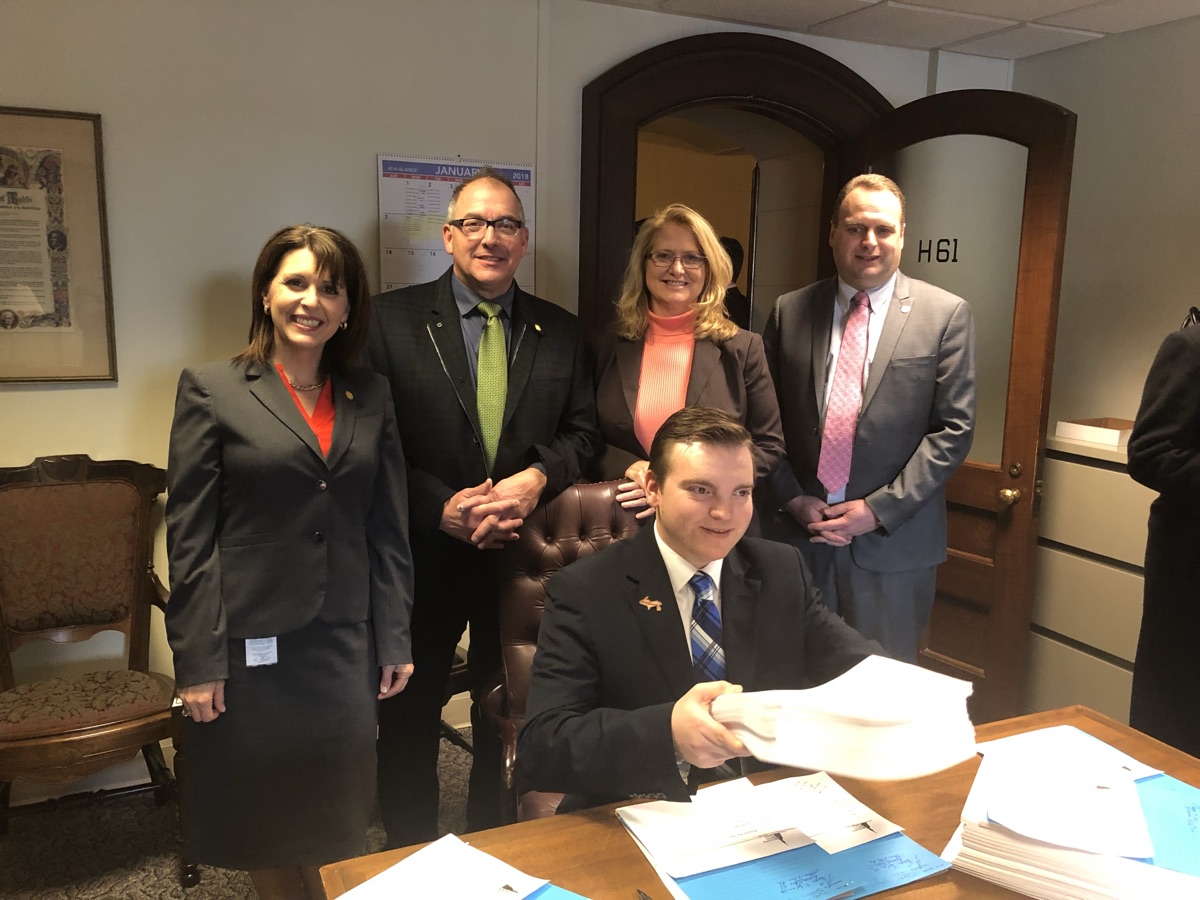 Beau LaFave working on car insurance reform legislation with colleagues